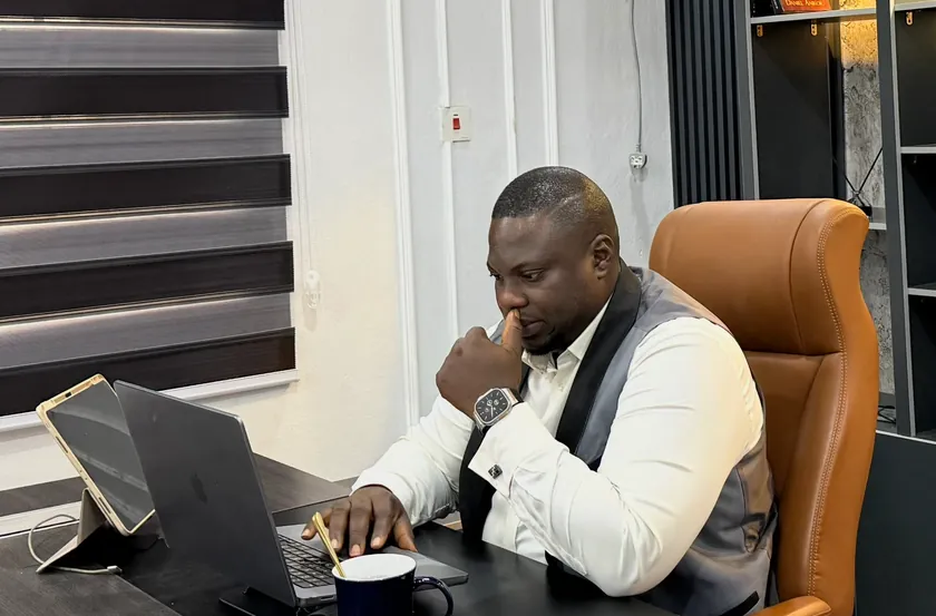 Fredrick Eghosa working at his laptop in his office